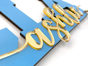 Angle view of collegiate sign, showing gold acrylic layered on blue sign.
